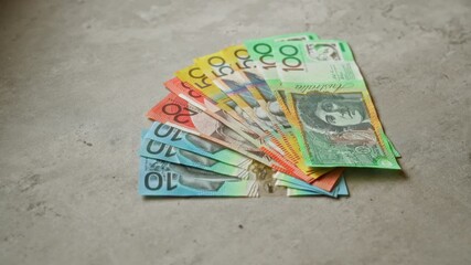 Australian banknotes of various denominations spread on a concrete surface, showcasing colorful currency notes and financial wealth.