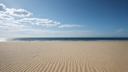 a sandy beach with a blue sky and white clouds