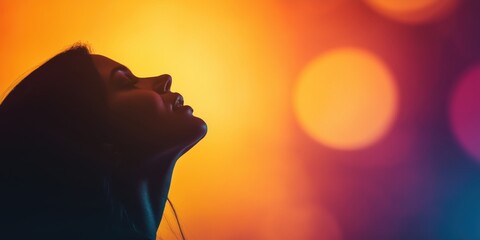Naklejka premium A silhouette of a woman profile stands against a vibrant, glowing background, capturing the essence of individuality and the beauty of self-expression in a striking visual contrast.
