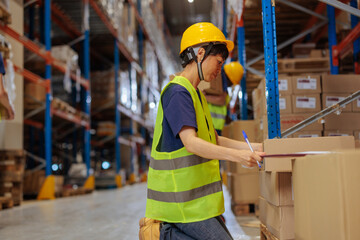 Female Asian warehouse worker sorting packages