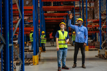 Warehouse manager and a worker looking up at the racks