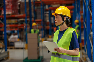 Female Asian warehouse worker holding a tablet