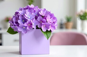 Fototapeta premium Romantic bouquet of lilac hydrangeas in a box against a light interior and a large window. Space for text. Ideal for advertising flower shop delivery, congratulations
