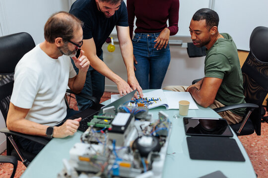 Engineers collaborating on innovative robotics project in modern office