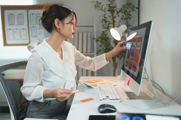Attractive female designer points to whiteboard with project of website phone ux ui and explains design process during presentation Online planning in the modern office.