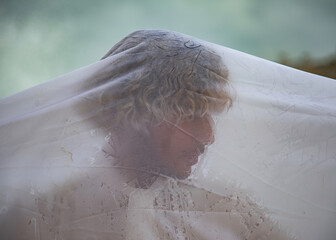 Blonde young man wearing a white lace shirt covered in a white sheer fabric