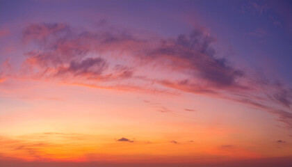 Obraz premium sunset cloudscape Panoramic with rich purple and pink tones blending into orange at horizon, tranquil evening sky view, natural dusk setting, soft wispy cloud formation, twilight backdrop