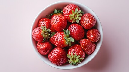 top down view of plain white ceramic bowl filled with fresh strawberries centered on clean white background