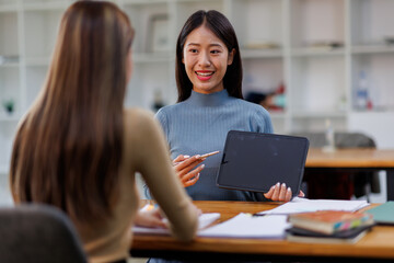 Two asian female creative agency casual meeting discussion working with laptop, analyze planning and financial statistics and investment market at office.
