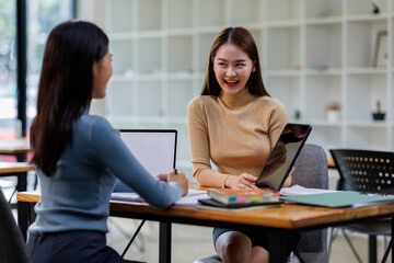 Obraz premium Two asian female creative agency casual meeting discussion working with laptop, analyze planning and financial statistics and investment market at office. 