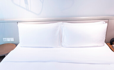 The white pillows on the bedroom on a bed with duvet case bedspread isolated on white background