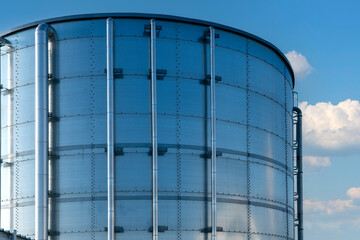 Industrial silos with blue sky and white clouds in the background