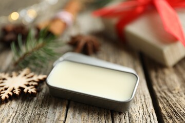 Natural solid perfume in container and Christmas decor on wooden table, closeup
