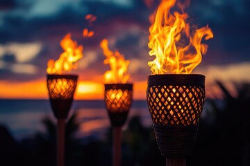 Tiki torches burning brightly at sunset on tropical beach