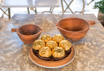 Generated Imag Several chocolate candies wrapped in gift paper with wooden utensils on a wooden table, close-up, isolated on a white background.e