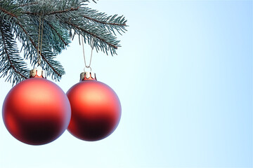 Two red Christmas baubles hanging on a pine tree branch against a soft blue sky background, creating a tranquil and festive seasonal ambiance.