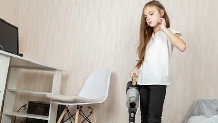Little girl using vacuum cleaner in room