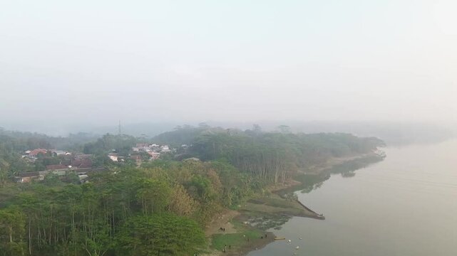 4k footage of a lake with calm water in the morning, covered in a thin mist