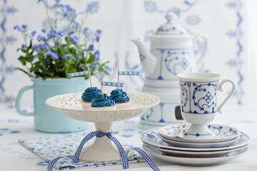 Blue themed tea setup with cupcakes and floral porcelain