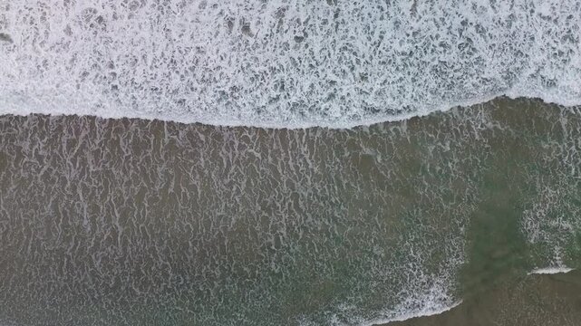 4k footage of foamy waves crashing, with angels from above