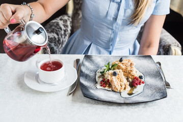 woman eating cake and drinking tea