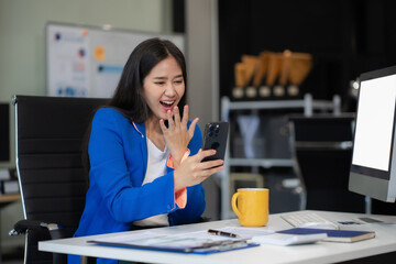 Asian business woman are excited business success with inspiration from their excellent financial results that are happy working in a modern office on a computer.