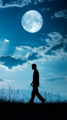 Silhouette of a walking man against a blue sky and moon