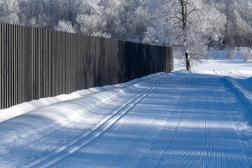 Winter, frosty and sunny mornings. Winter landscape and trees in the frost. A ski run laid along a water channel. Lots of free space for your text.