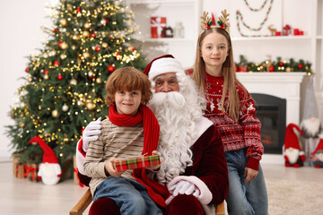 Christmas celebration. Santa Claus and kids with gift box at home