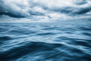 Fototapeta premium Calm ocean waves under a cloudy sky.