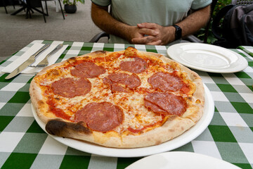 Pepperoni Pizza on Restaurant Plate, Salami Pizza with Olives, Tomatoes and Mozzarella Cheese
