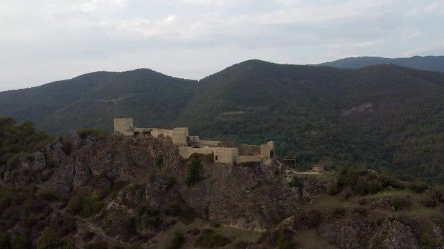 Aerial orbits stone Modinakhe Castle on mountain ridge in Georgia