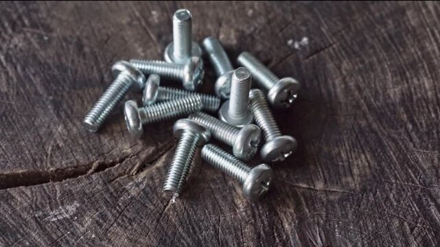 video of screws hardware on wooden background, slowly rotating