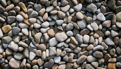 Naklejka premium Close-up of seamless natural pebble stones showcasing varied shapes, smooth textures, and organic tones, ideal for backgrounds.