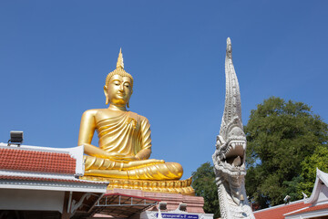 Fototapeta premium Beautiful big Golden Buddha statue under clear and sunny sky in Khueang Nai District, Ubon Ratchathani, Thailand