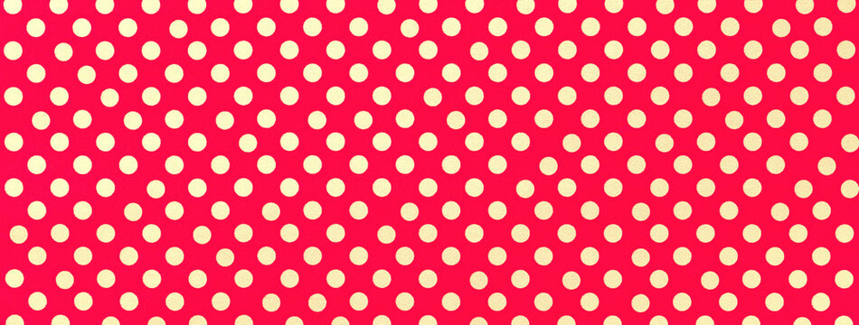 Bright red background from wrapping paper with pattern of yellow polka dot, macro.