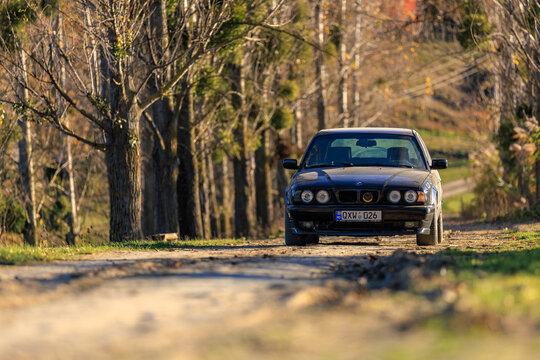 BMW E34 station wagon driving along a rural tree-lined road in Leordoaia Moldova, November 3, 2024