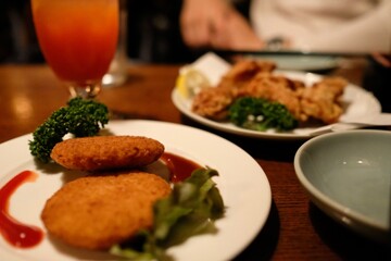 
Cream croquettes, karaage (fried) chicken, and a tequila sunrise cocktail at Vagabond, a jazz cafe and “drinking den” with live music in Shinjuku - Tokyo, Japan