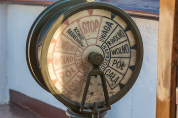 A vintage ship telegraph, used for transmitting engine room commands, with markings in Polish.