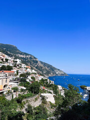Naklejka premium Scenic coastal view of hillside town with vibrant blue sea and sky. Positano, Italy.
