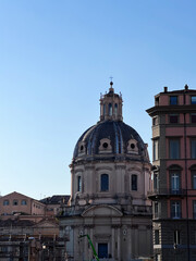 Historic dome architecture with surrounding buildings under clear sky. Rome, Italy.