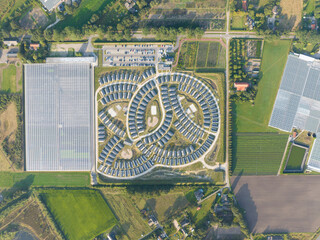 Workers housing next a greenhouse and on industrial business park. Workers migration, aerial drone...