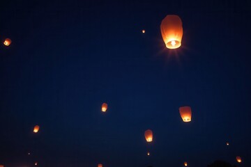Obraz premium Enchanting Night Sky with Floating Lanterns Illuminating the Darkness in a Magical Display of Light and Serenity Overhead