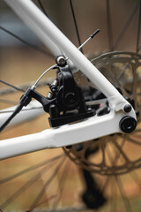 Fototapeta premium Close-up of a bicycle wheel with visible spokes and tire tread, highlighting mechanical details and urban mobility, ideal for transportation, cycling, and mechanical design projects.