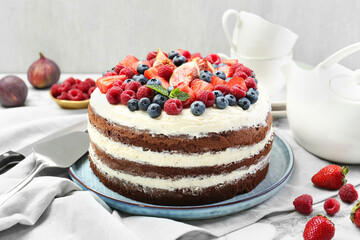 Delicious chocolate sponge cake with berries served on white table