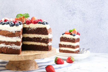 Delicious chocolate sponge cake with berries served on white table