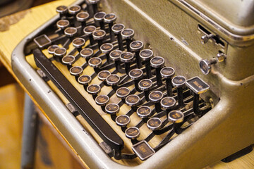 Close-up view of an antique typewriter, showcasing its aged keys and metallic body. A nostalgic...