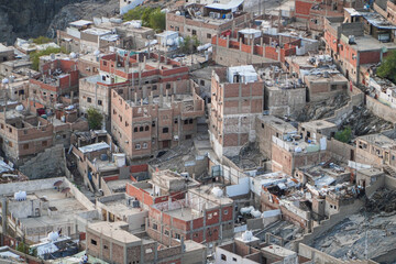 An aerial shot capturing a densely packed neighborhood clinging to a mountainside. Buildings are closely clustered together. Aerial View of a Densely Populated Mountainside Neighborhood.