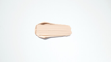 Cosmetic makeup cream sample isolated on white. Liquid foundation smudge. Beauty skincare texture swipe swatch