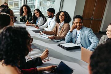 Diverse group of professionals in a seminar setting, engaging in lively discussion around a...